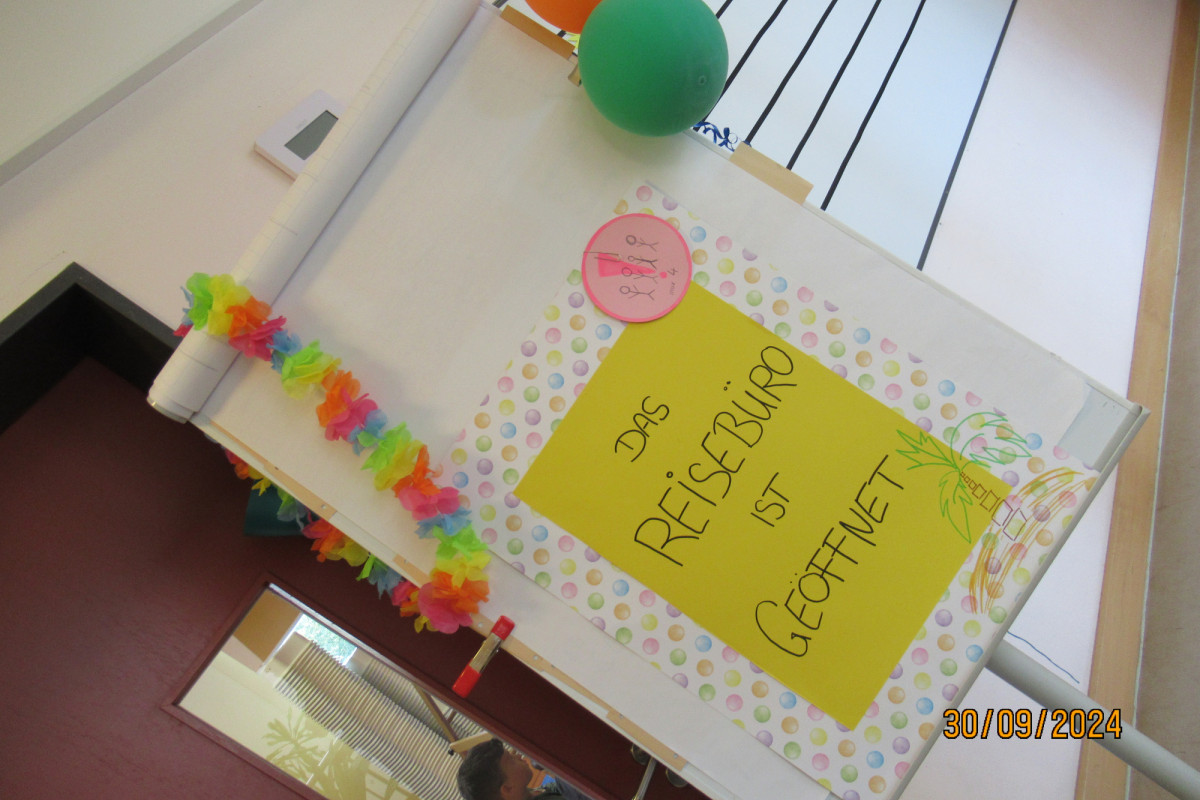 Schild mit der Aufschrift: Das Reisebüro ist geöffnet!