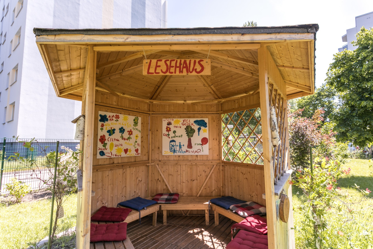 Halboffenes Lesehaus im Freien mit Kissen.