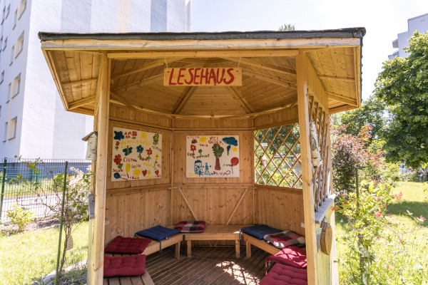 Halboffenes Lesehaus im Freien mit Kissen.