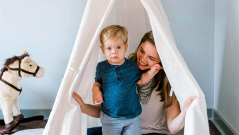 Kleiner Junge versteckt sich mit seiner Mutter in einem Tipi