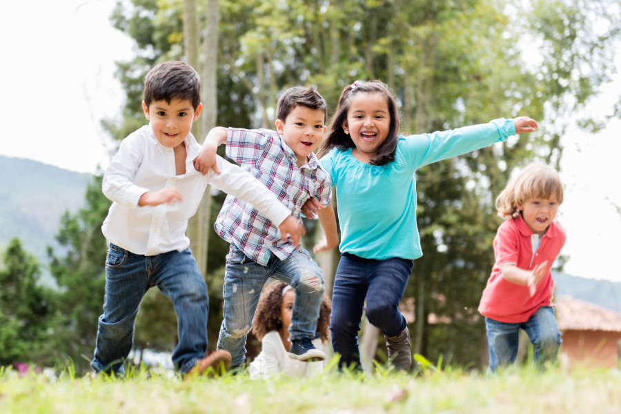 Kindergruppe rennt über eine großzügig gestalte Spielwiese