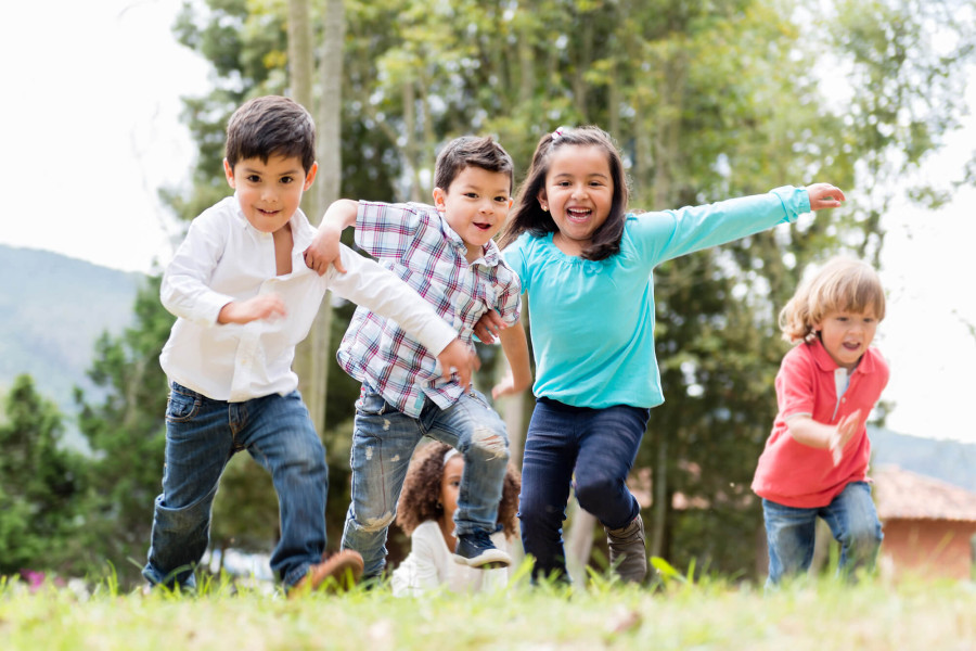 Kindergruppe rennt über eine großzügig gestalte Spielwiese