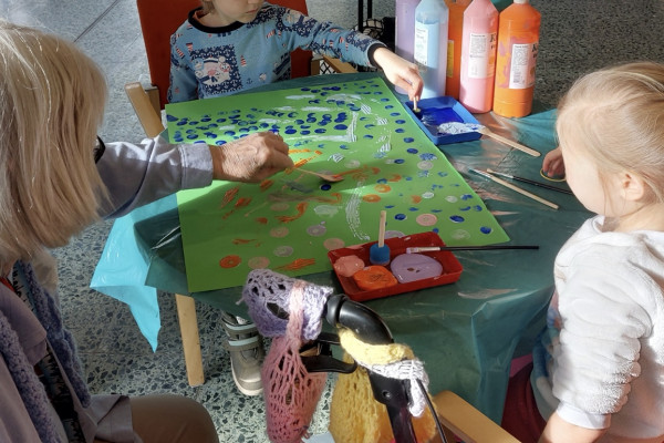 Kita-Kinder spielen mit einer Seniorin