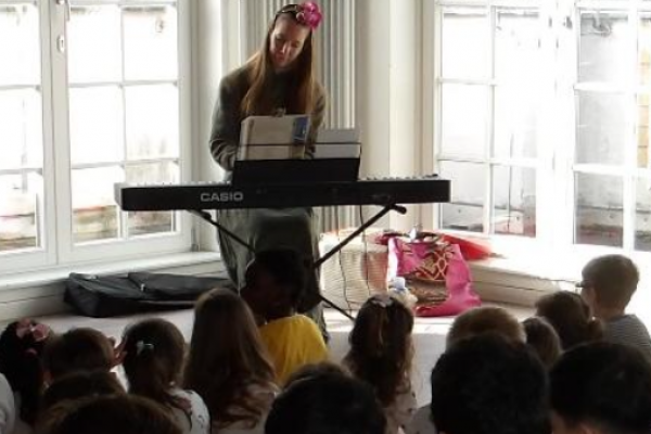 Kita-Kinder hören der Musikerin zu