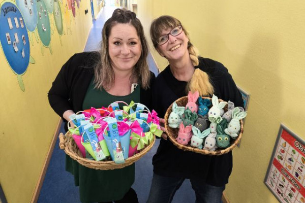 Kita Kolleginnen halten Korb voller kleiner Ostergeschenke
