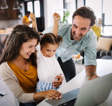 Kita Nordwest - Kinderschutz Downloads Zwei Erwachsene sitzen mit einem Kind vor einem Laptop und lächeln gemeinsam