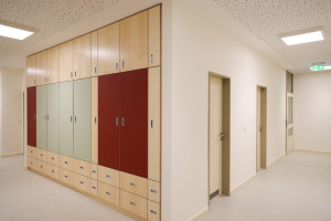 Kita Cunostraße Flur und Schrankwand in hellen Farben und rot