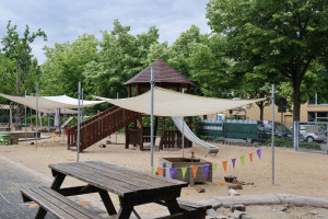 Sandspielplatz mit Klettergerüst, Bank und Girlande