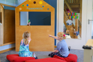 Kinder sitzen vor Puppentheater in der Kita Freinet-Haus Entdeckerland
