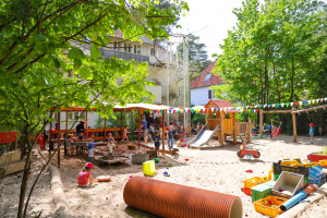 Großer Sandspielplatz mit Spielsachen der Kita Frohnatur