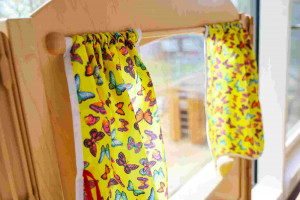 Kita Nordwest: Kita Libelle Puppenhaus Fenster mit buntem Schmetterlingsvorhang