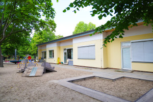 Innenhof mit Sandkasten, Schaukel und Kletterhügel