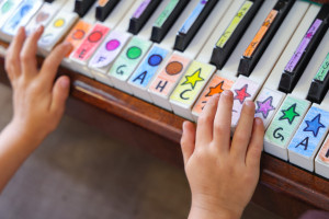 Kind übt Klavierspielen in der Kita Tausendfühler