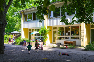 Kinder spielen vor dem Gebäude der Kita Wassergeister