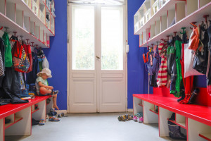 Garderobe mit roter Bank und blauer Wand in der Kita Wilhelmsaue